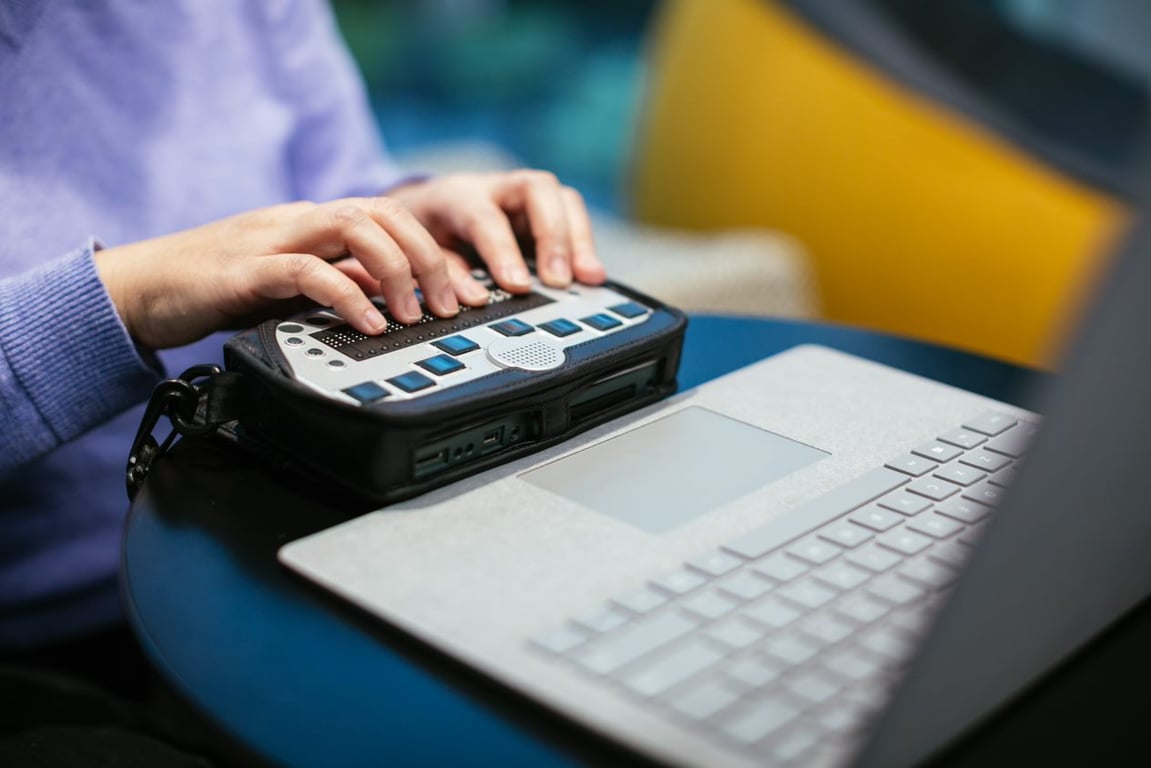 Mujer utilizando un teclado touch conectado a un portátil convencional.