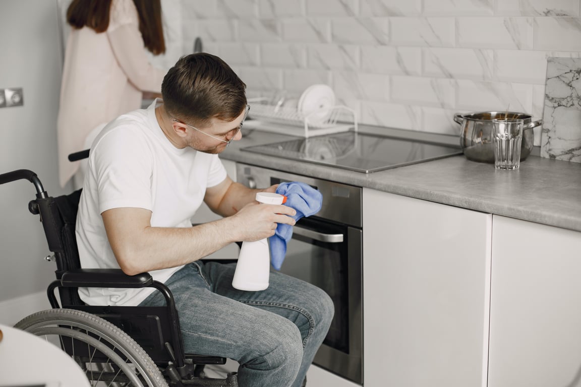 Usuario de silla de ruedas limpiando su cocina