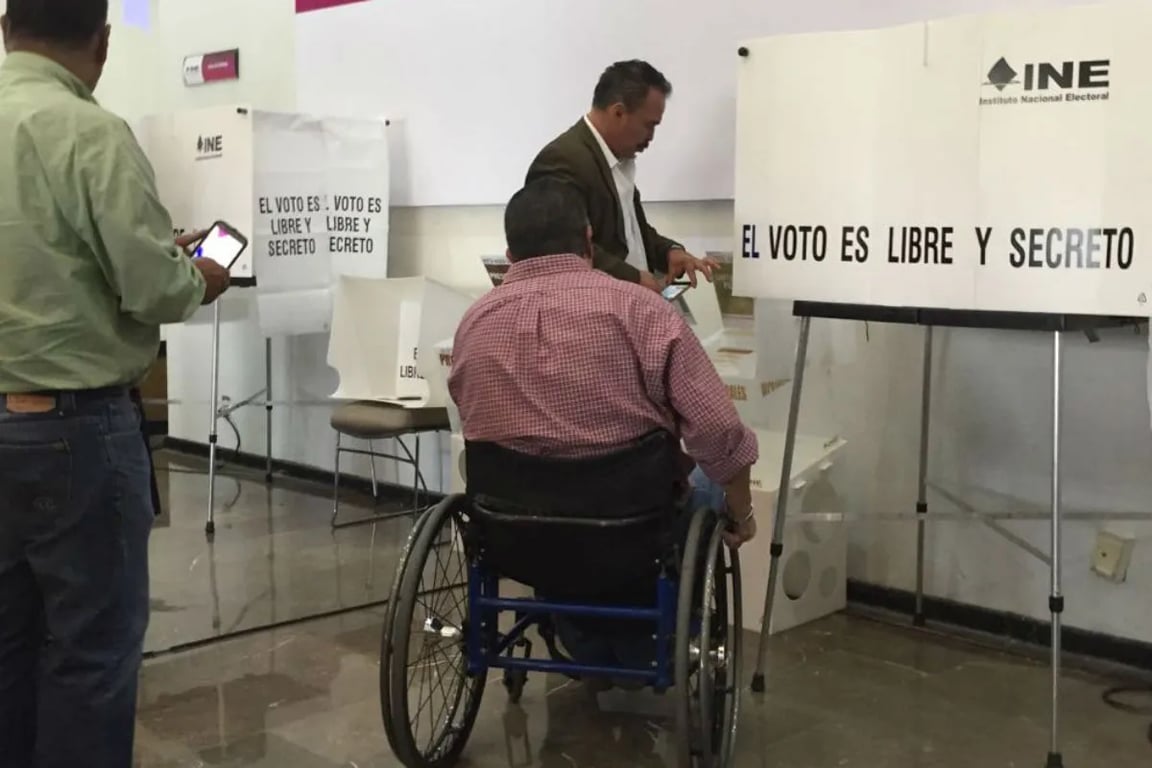 Usuario de silla de ruedas votando en una casilla para personas con discapacidad del INE