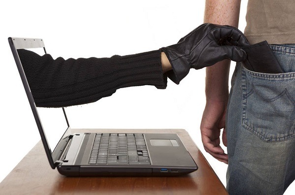 Ladrón sacando la mano de la pantalla de una laptop para tomar la cartera de un hombre de pie frente al ordenador