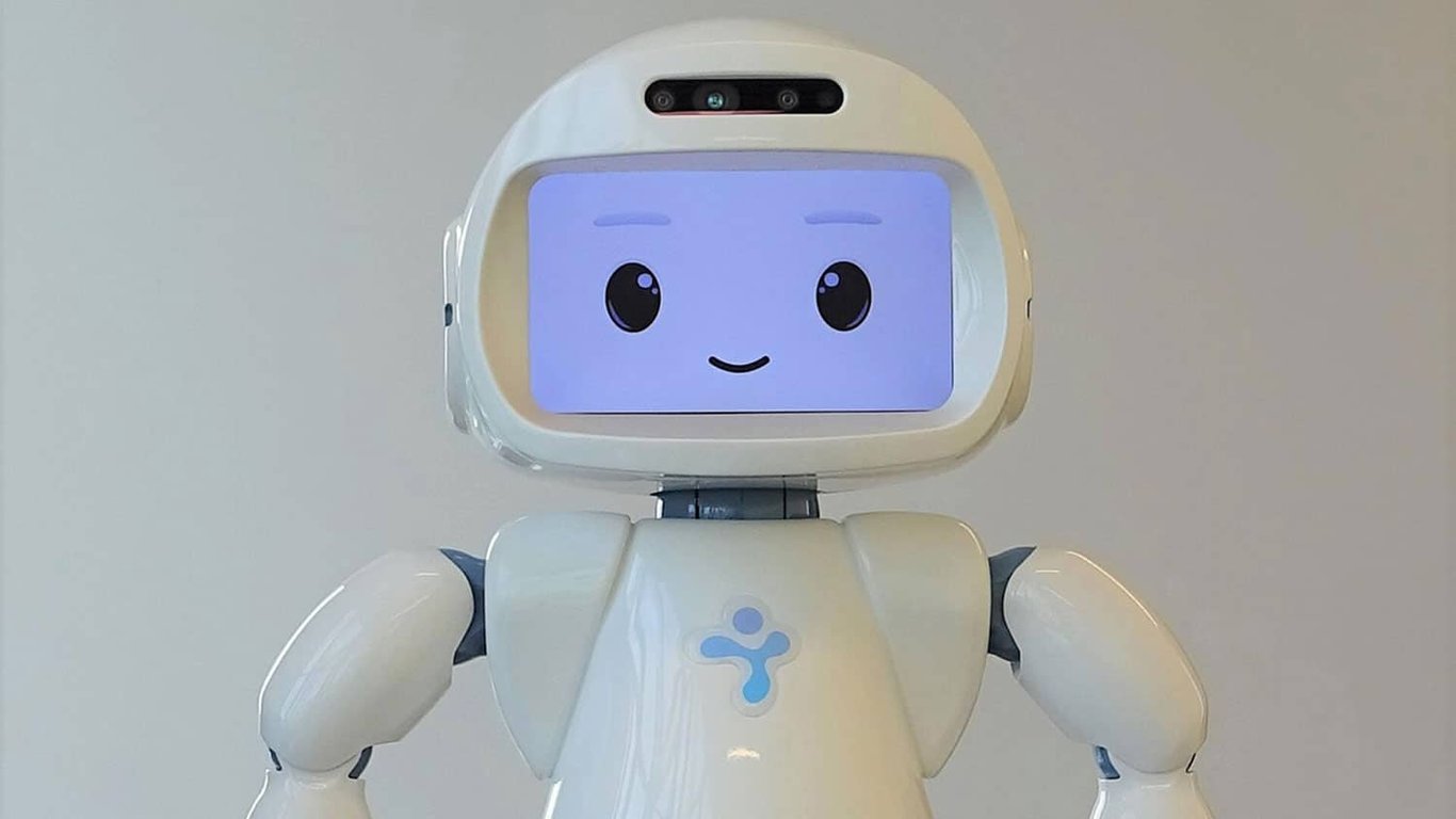 Robot con forma humana cuyo rostro es una pantalla que proyecta una sonrisa