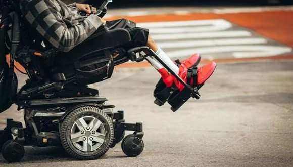 Usuario de silla de ruedas con prótesis en ambos pies.