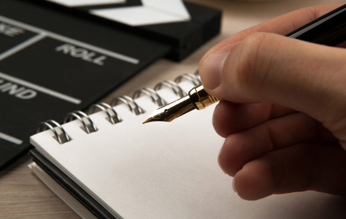 Persona escribiendo en una libreta en blanco