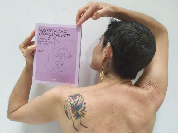 Mujer con lupus sosteniendo un cartel que dice "Nos esforzamos y somos valientes"