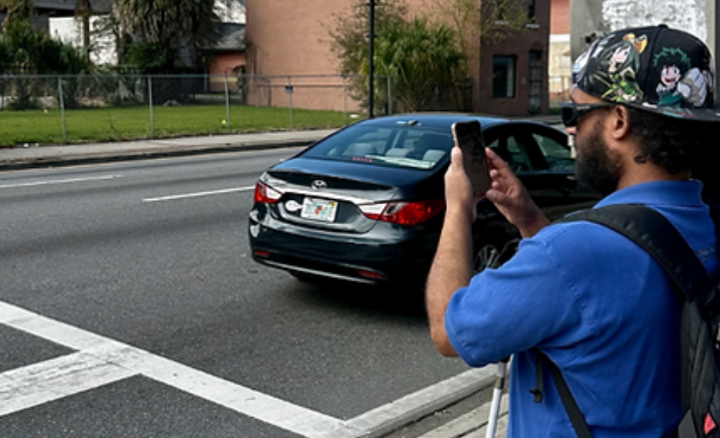 Persona ciega cruzando una calle con ayuda de la app OKO