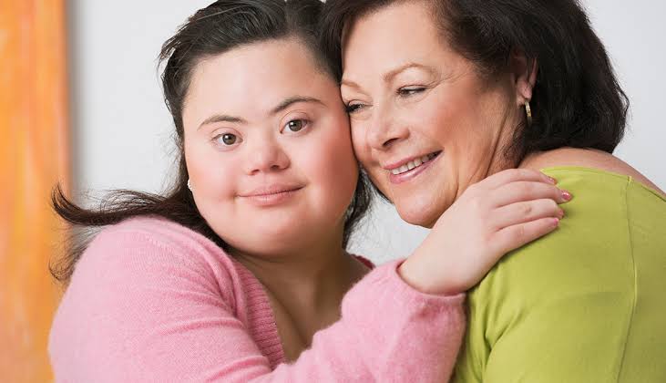 Madre abrazando a su hija con síndrome de Down