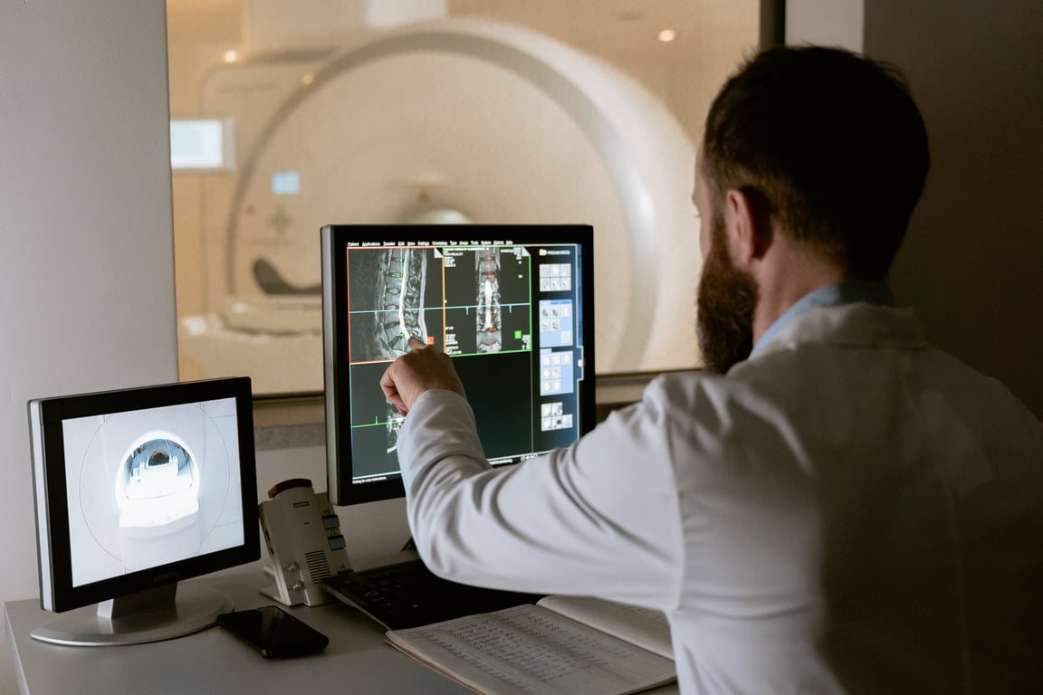 Médico analizando un monitor con una radiografía de una espalda