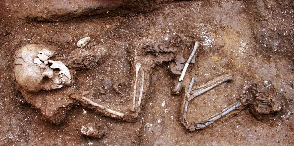 Esqueleto humano enterrado en la tierra