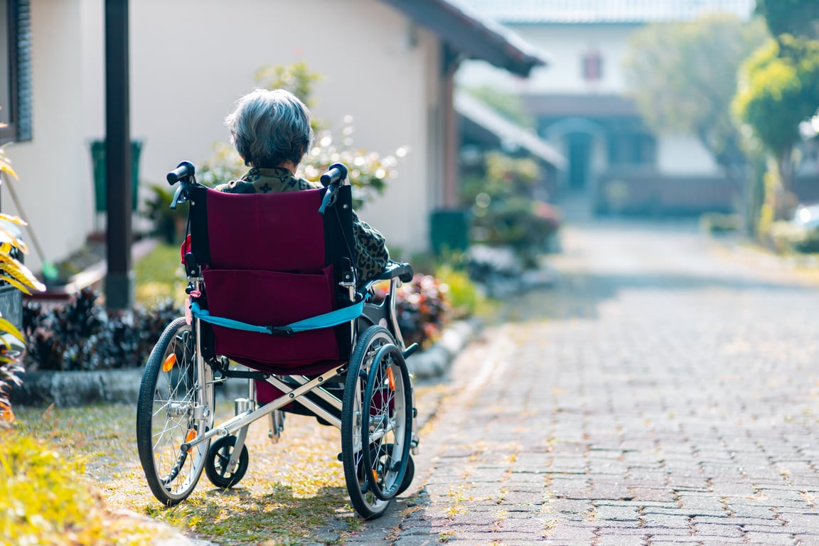 Una mujer en silla de ruedas en una calle solitaria.