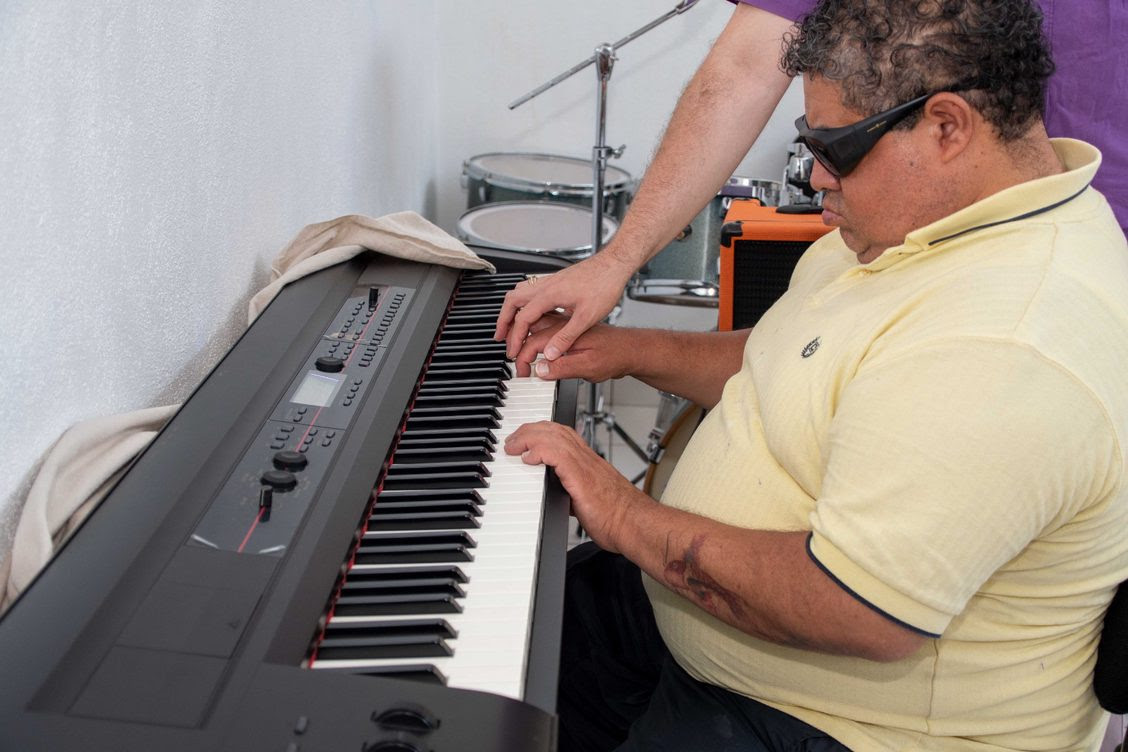 Fotografía de una persona con discapacidad visual aprendiendo a tocar el piano.