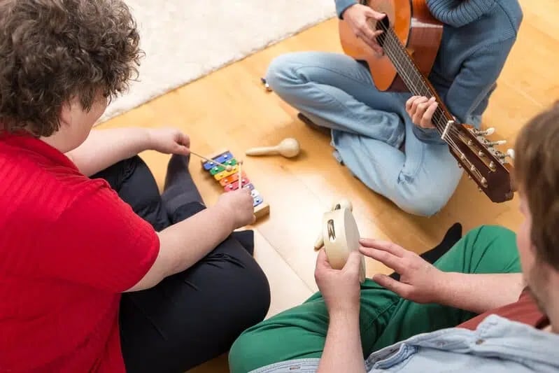 Tres personas tocando un instrumento musical cada una