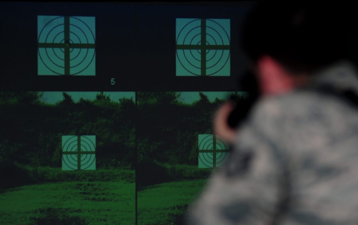 U.S. Air Force Staff Sgt. Ryan gulley, 633rd Security Forces Squadron training instructor, fires at a simulated target at Langley Air Force Base, Va., Jan. 26, 2015. In addition to realistic scenarios, the new weapons simulator also includes target practice and gives real-time feedback to help improve form and technique. (U.S. Air Force photo by Airman 1st Class Areca T. Wilson/Released) (Photo was cropped and contrasted for effect)
