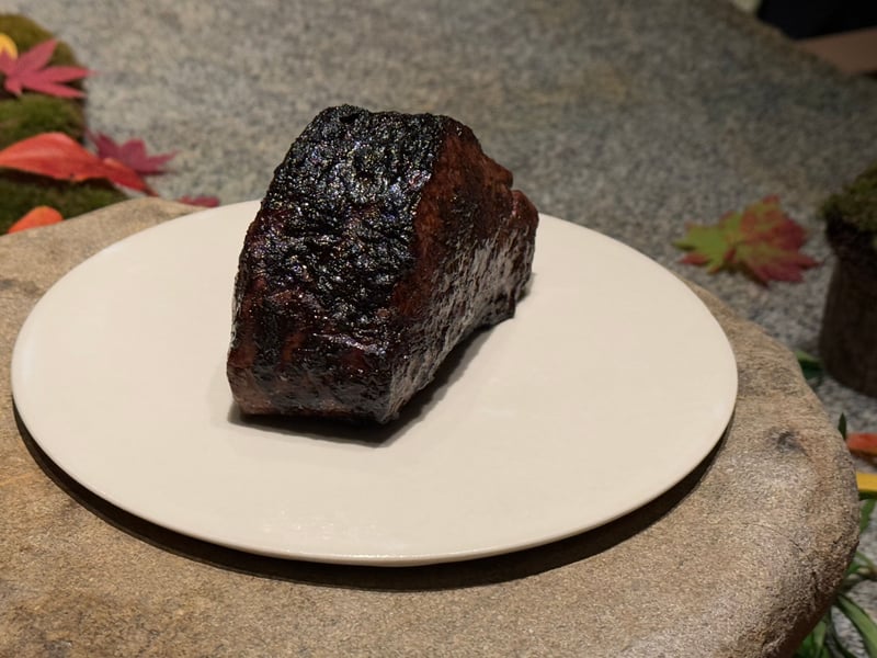 表面を黒く焼き上げた近江牛フィレの塊を皿にのせて見せる