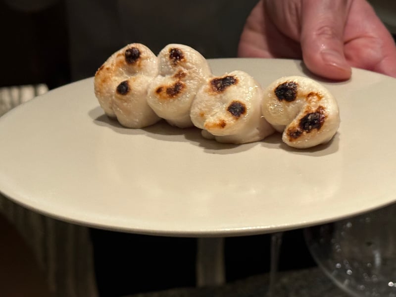 皿に並べた、焼き目を付けた河豚の白子4つ