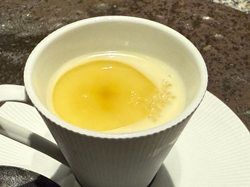 カップに注がれた冷たい新玉ねぎとじゃがいものスープ。表面に粒が散る
