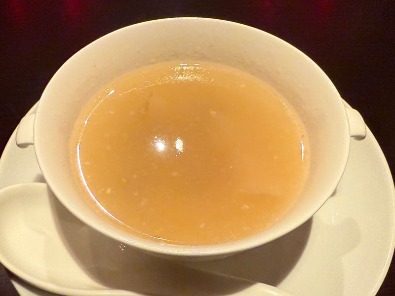 耳付きの白い碗に注いだ、澄んだ琥珀色のスープ