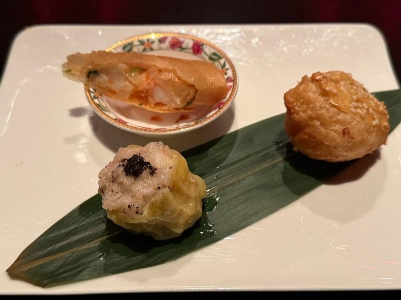 笹の葉を敷いた角皿に、黒トリュフをのせた焼売、丸く揚がった蟹肉入りのパイ、小皿に半分に切ったエビ春巻