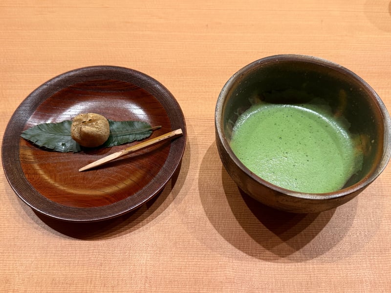 木の器に葉を敷いて栗きんとんをひとつ、黒文字を添える。隣に抹茶