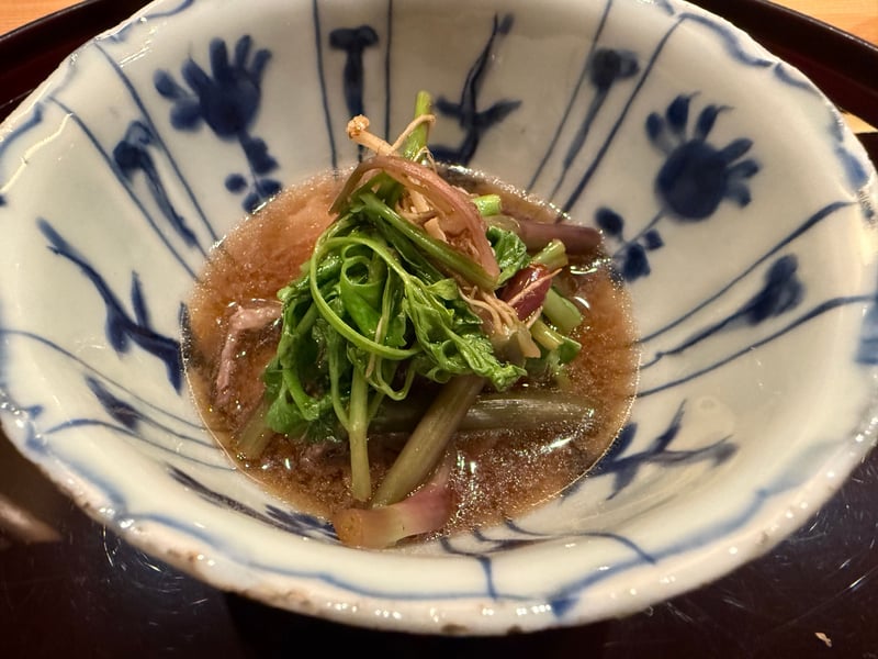 染付の小鉢に張った出汁と、くぐらせた熊肉・野芹・茗荷