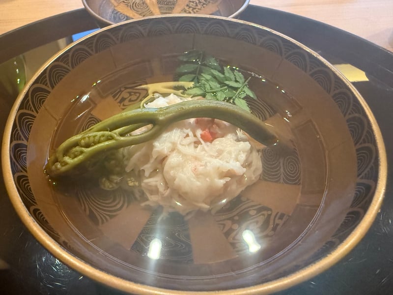 漆の椀に浮かぶ紅ズワイのしんじょうと、渡したわらび、木の芽