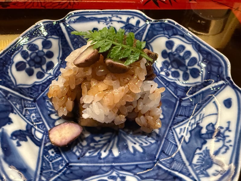 鰻としいたけを仕込んで蒸した米を、染付の小皿に盛った鰻蒸し