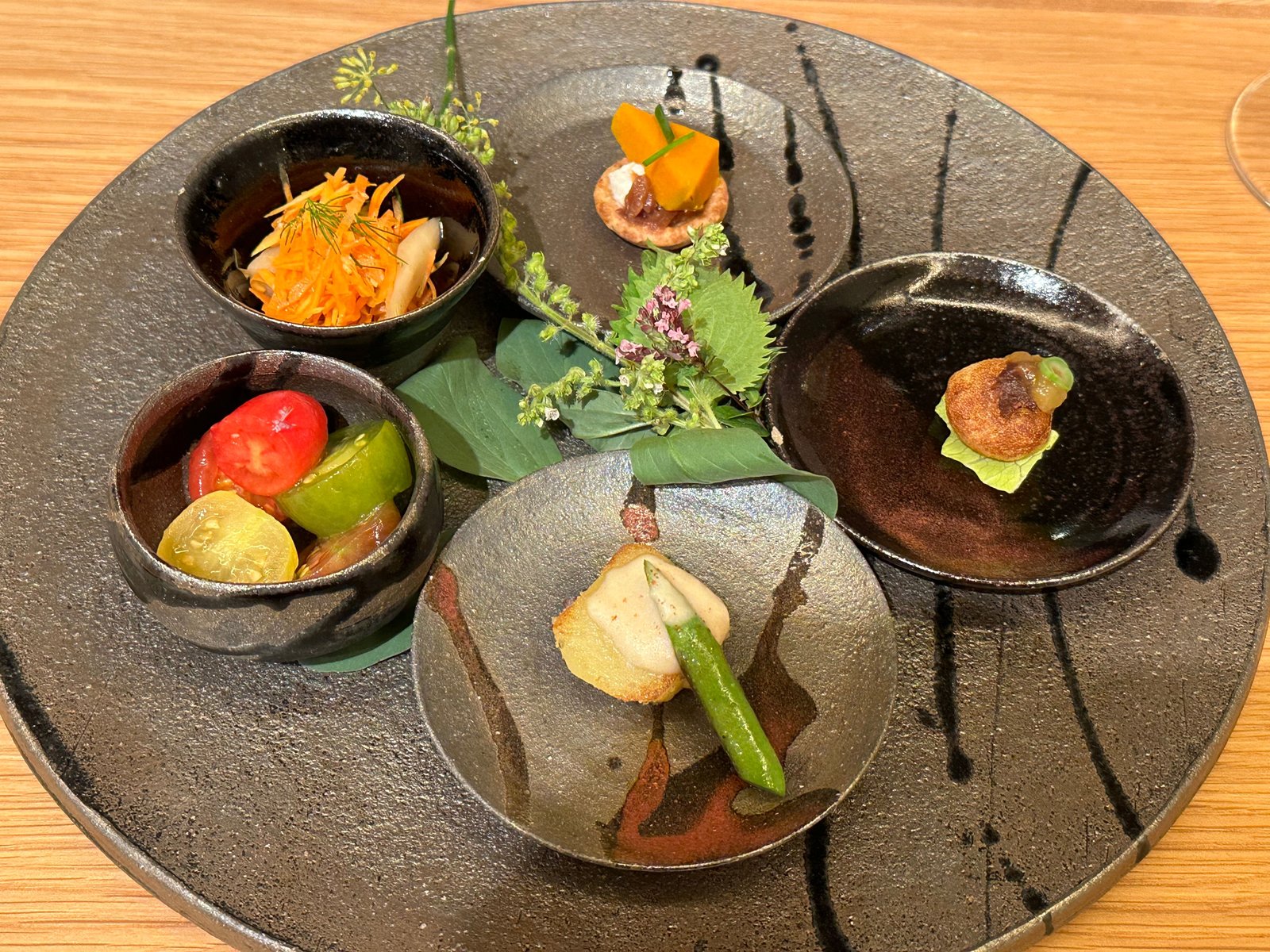 黒い大皿に、さかもと農園の野菜の小鉢が5つ