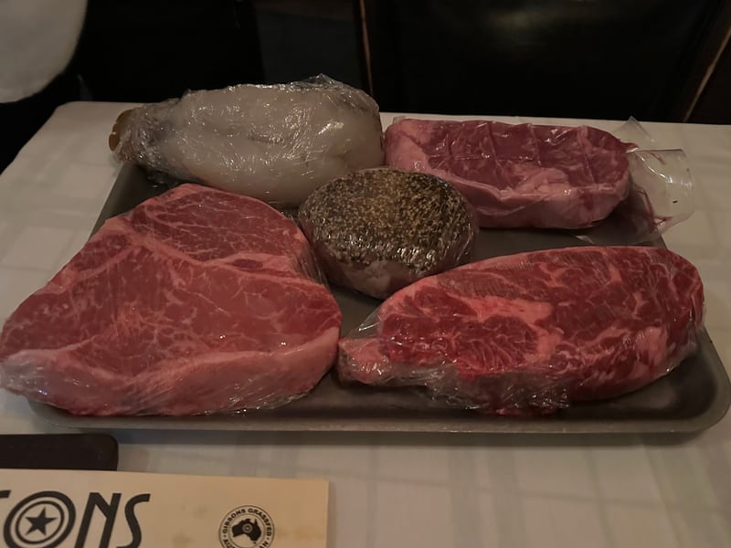 焼く前の生の肉を並べたトレイ。フィレ、ストリップ、胡椒をまとった一切れ