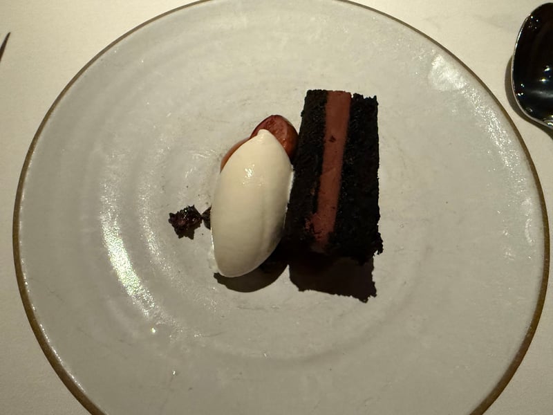 黒いチョコレートのケーキにガナッシュの層。白いアイスのクネルと、赤いいちじく