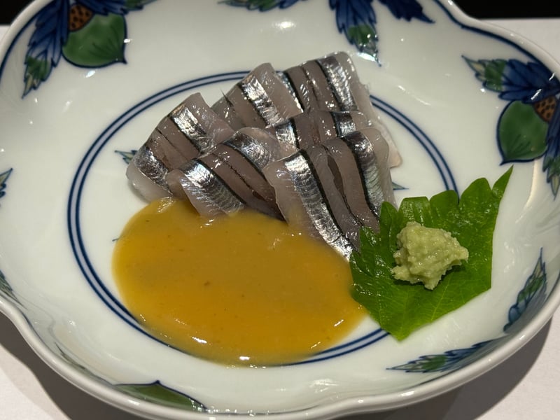 染付の鉢に、銀色の縞が並ぶきびなごの造り。黄色い酢味噌と、大葉の上のわさび。