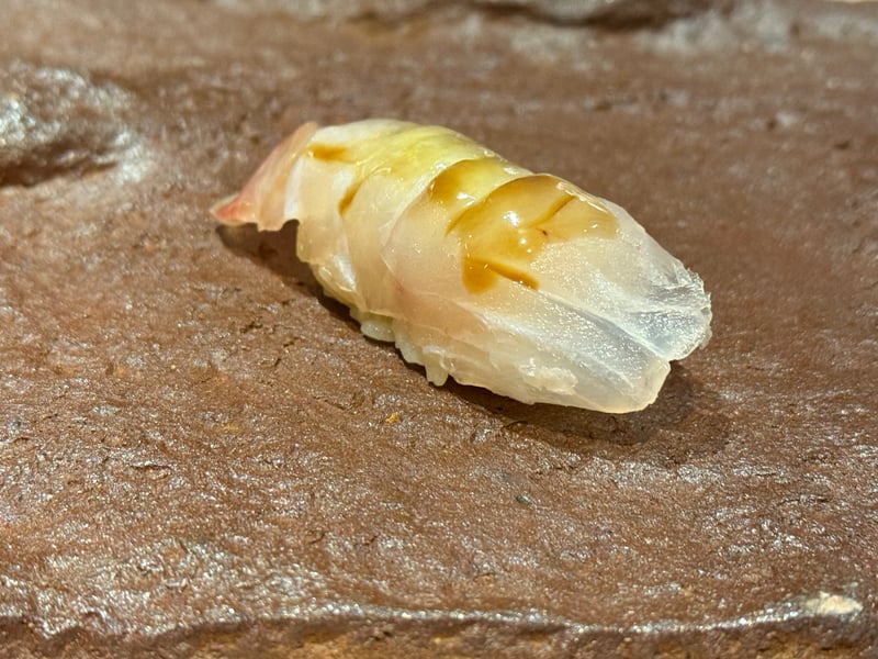 茶色い石の台にのった、真鯛の昆布締めの握り。