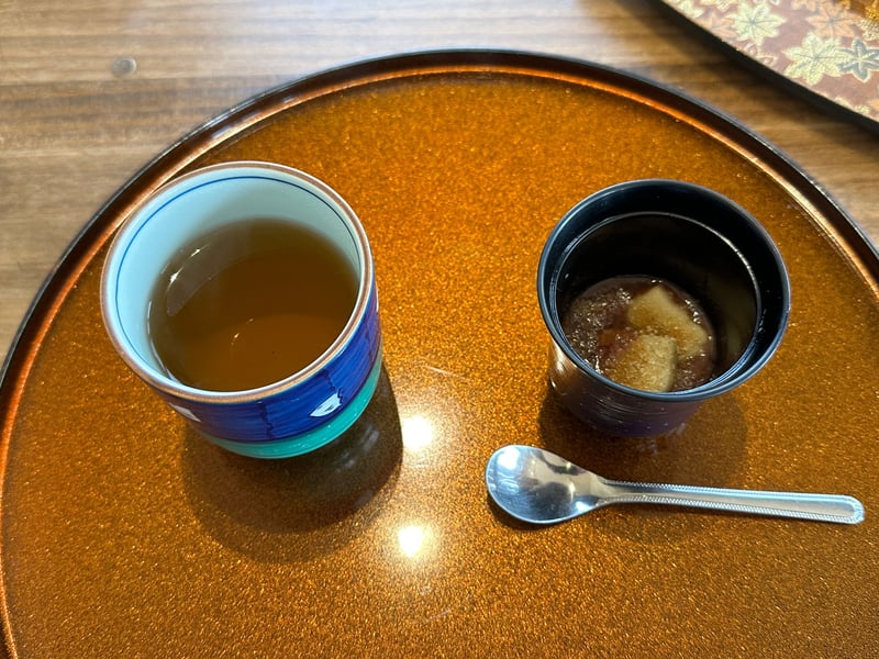 小豆と白い二切れを入れた黒い小鉢、隣に茶