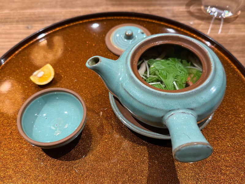 青磁の土瓶蒸しと猪口、檸檬。土瓶の口から水菜が見える