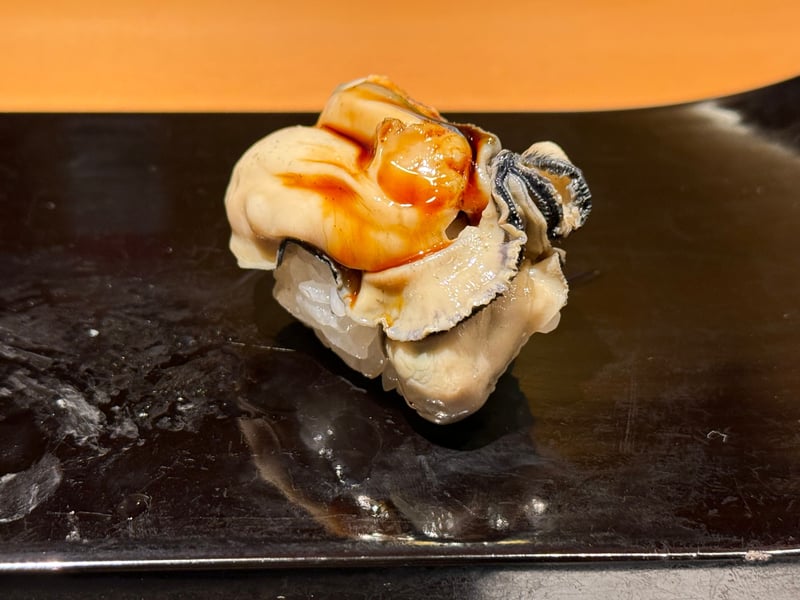 火を通した中島の牡蠣の握り。濃い色のタレが引いてある