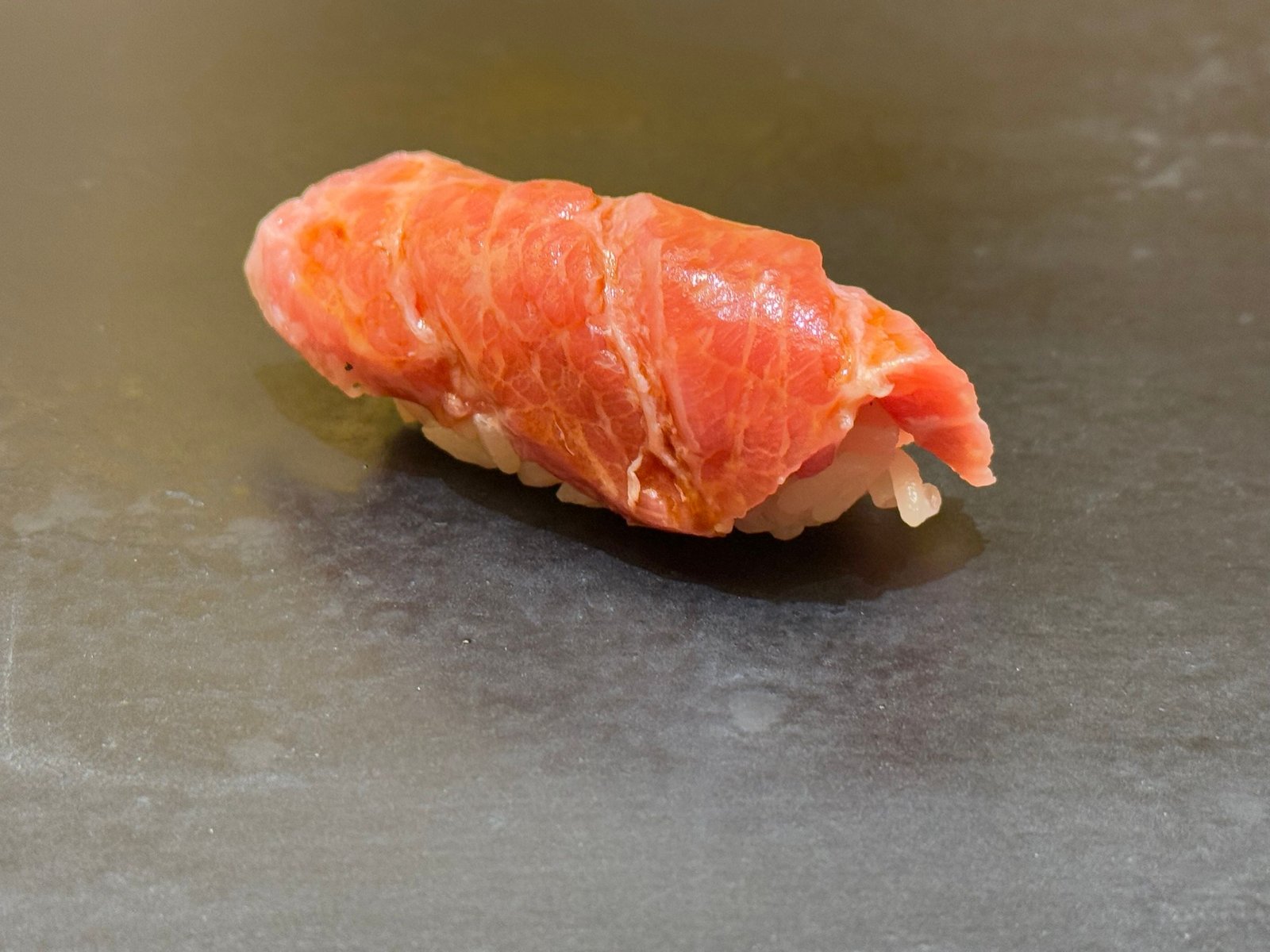 黒いつけ台に、佐渡のマグロのトロの握り