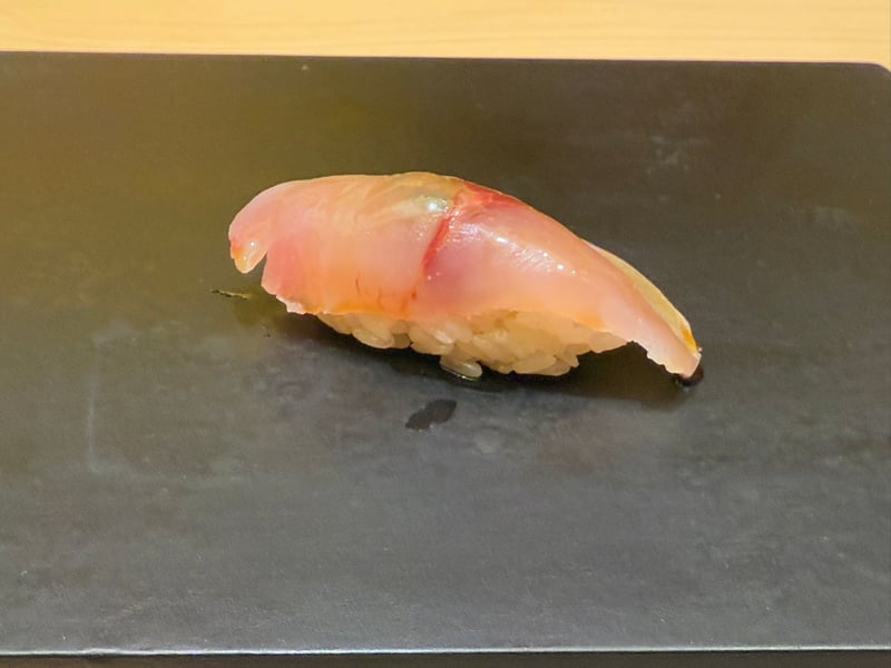 黒いつけ台に、銀皮を残した釣り鯵の握り