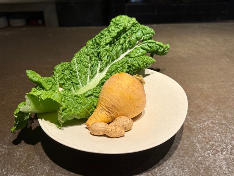 白い皿に、根の形のまま黄金かぶ、殻付きの落花生、ちぢれた葉のかつお菜
