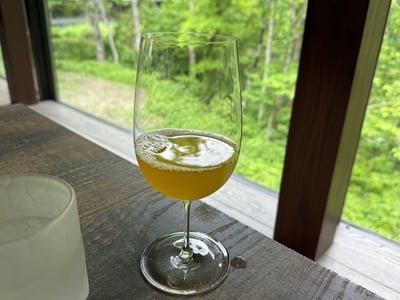 窓辺のグラスに注がれた、黄色がかった緑茶のドリンク