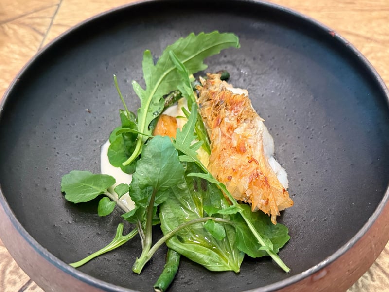 甘鯛の松笠焼き。立った鱗の横に葉物のサラダと白いソース