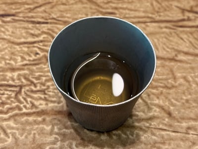 金属の器に注がれた、よもぎとローズマリーのお茶