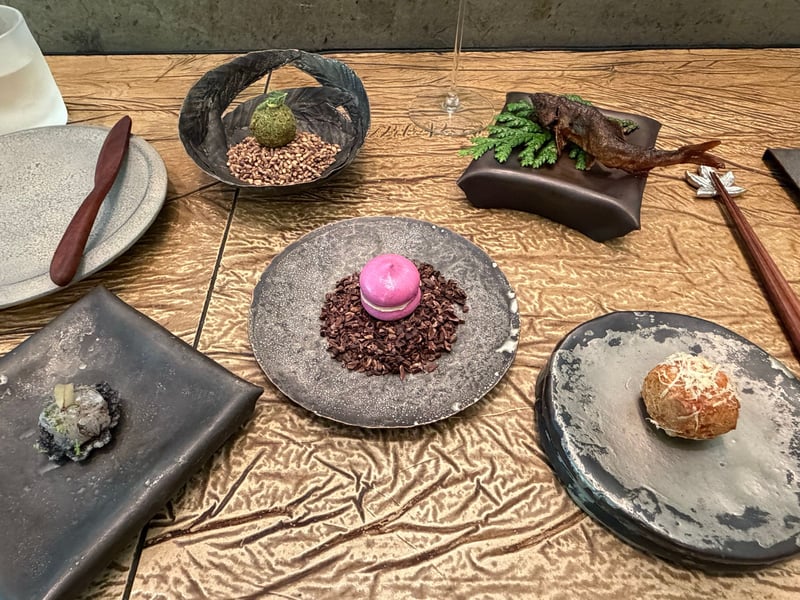 Prologue の小皿がカウンターに並ぶ。赤ビーツのメレンゲ、グジェール、串に刺した鮎など