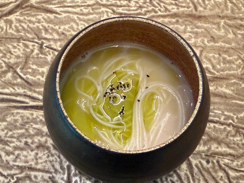黒い器に盛った大門素麺。蕗のオイルが緑の筋を引く