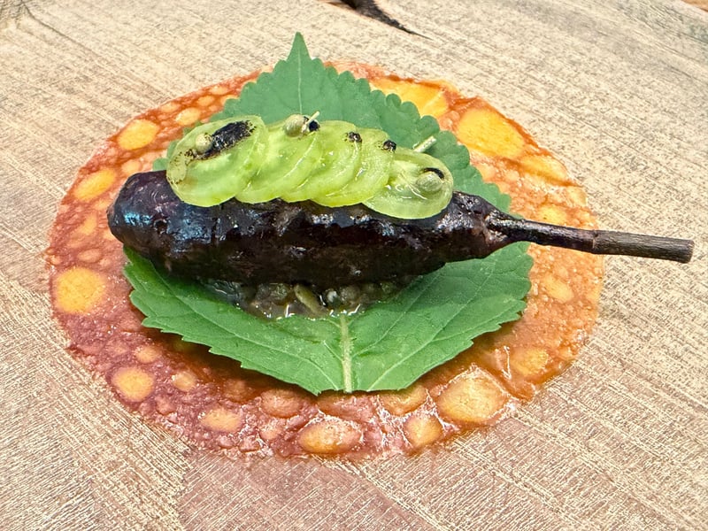 スッポンのつくねをエゴマの葉にのせ、グリーントマトを重ねた一皿