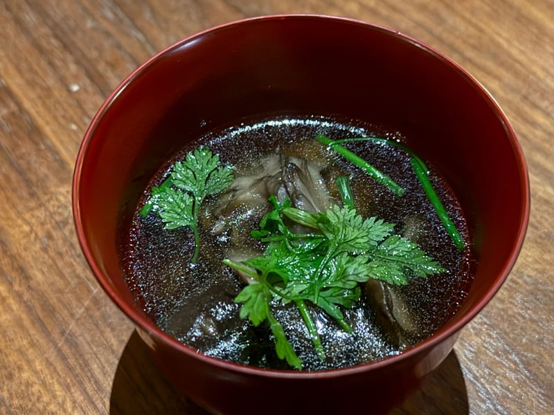 朱の椀に澄んだ濃い汁。きのこと春菊が浮かぶ