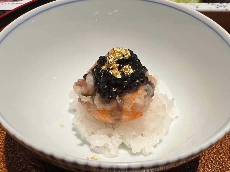 白飯の上に揚げた一玉をのせ、キャビアと金箔をあしらった卵かけご飯