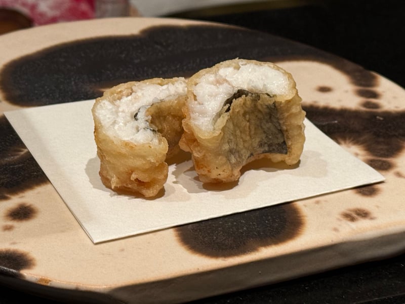 二つに切った伝助穴子の天麩羅、白い身と皮が断面に見えている