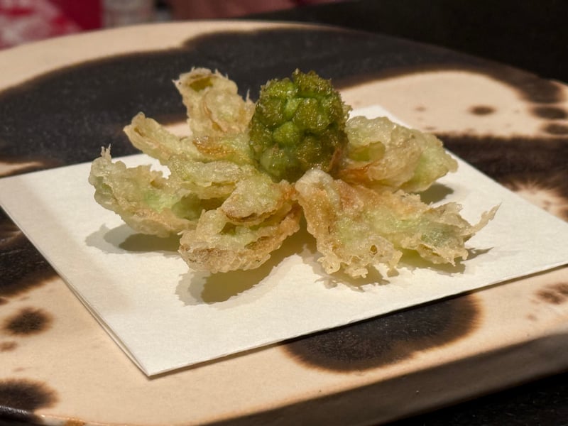 苞を開いて揚げた蕗のとう、中心の蕾が緑のまま立っている