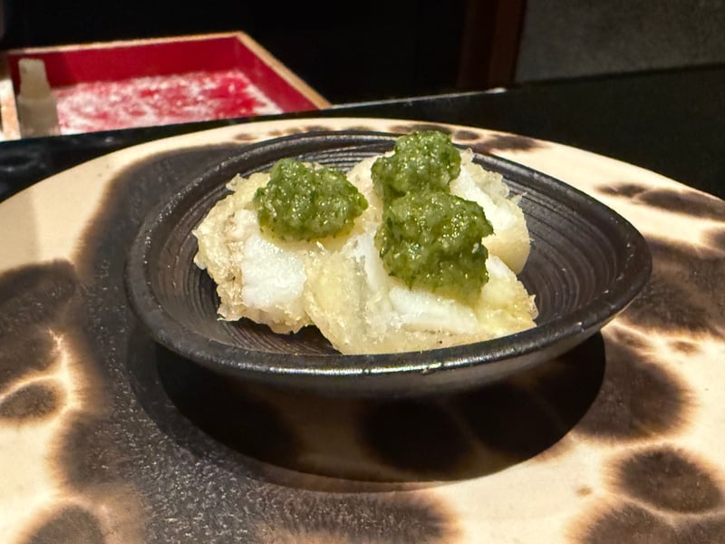 おろしたきゅうりをのせたおこぜの天麩羅、黒い小鉢に