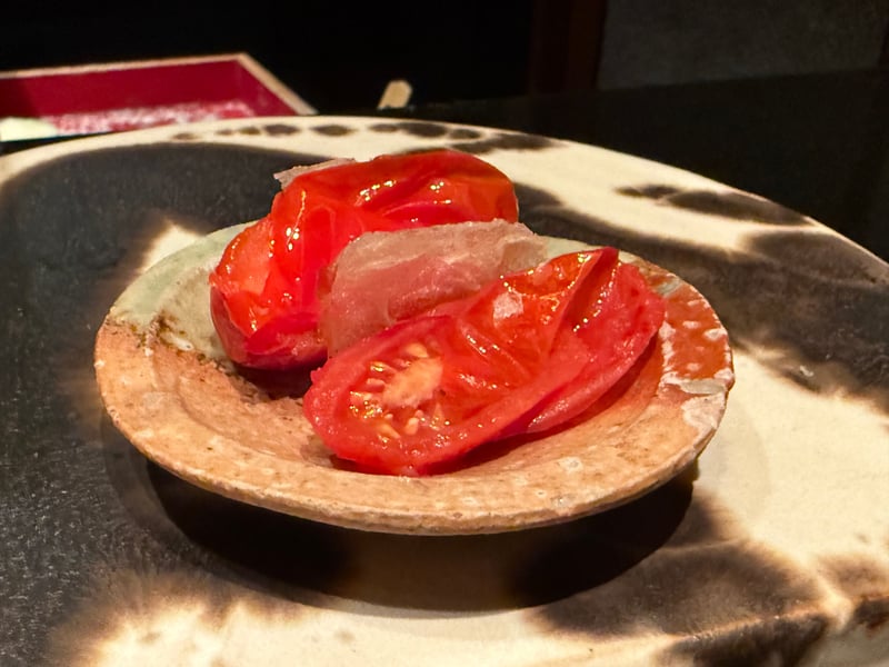 皮を湯むきしたトマト二切れと、あいだに挟んだ透き通った一枚