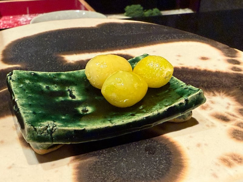 緑釉の角皿にのせた揚げた銀杏三粒
