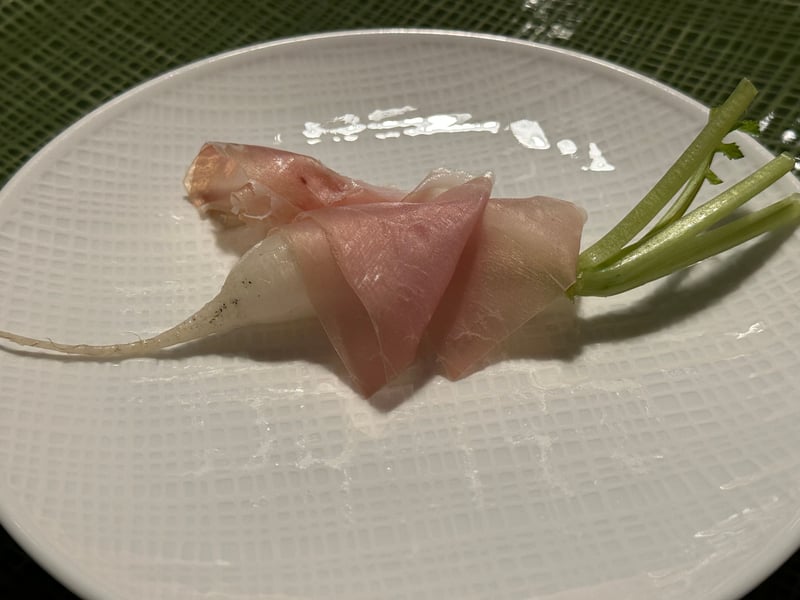 葉と根を残した小さな白い根菜に生ハムを巻いた一皿